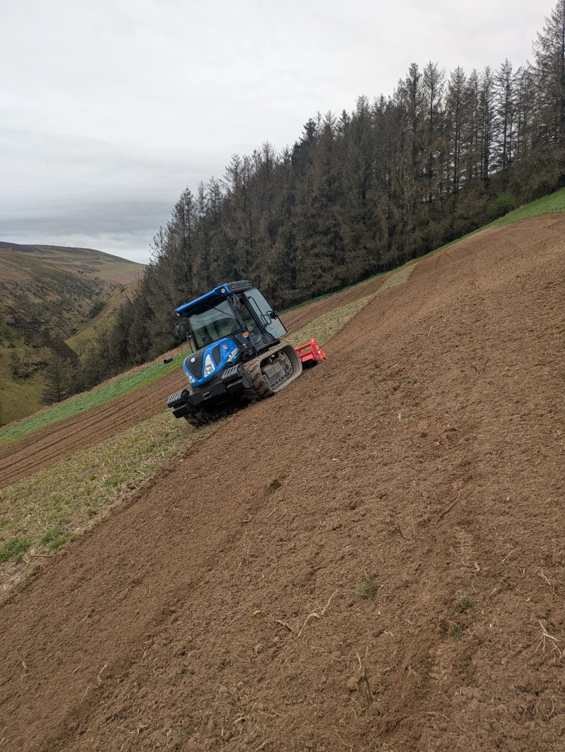 Tracked tractor working a steep field